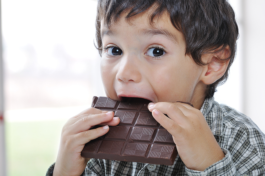 Little cute kid eating chocolate